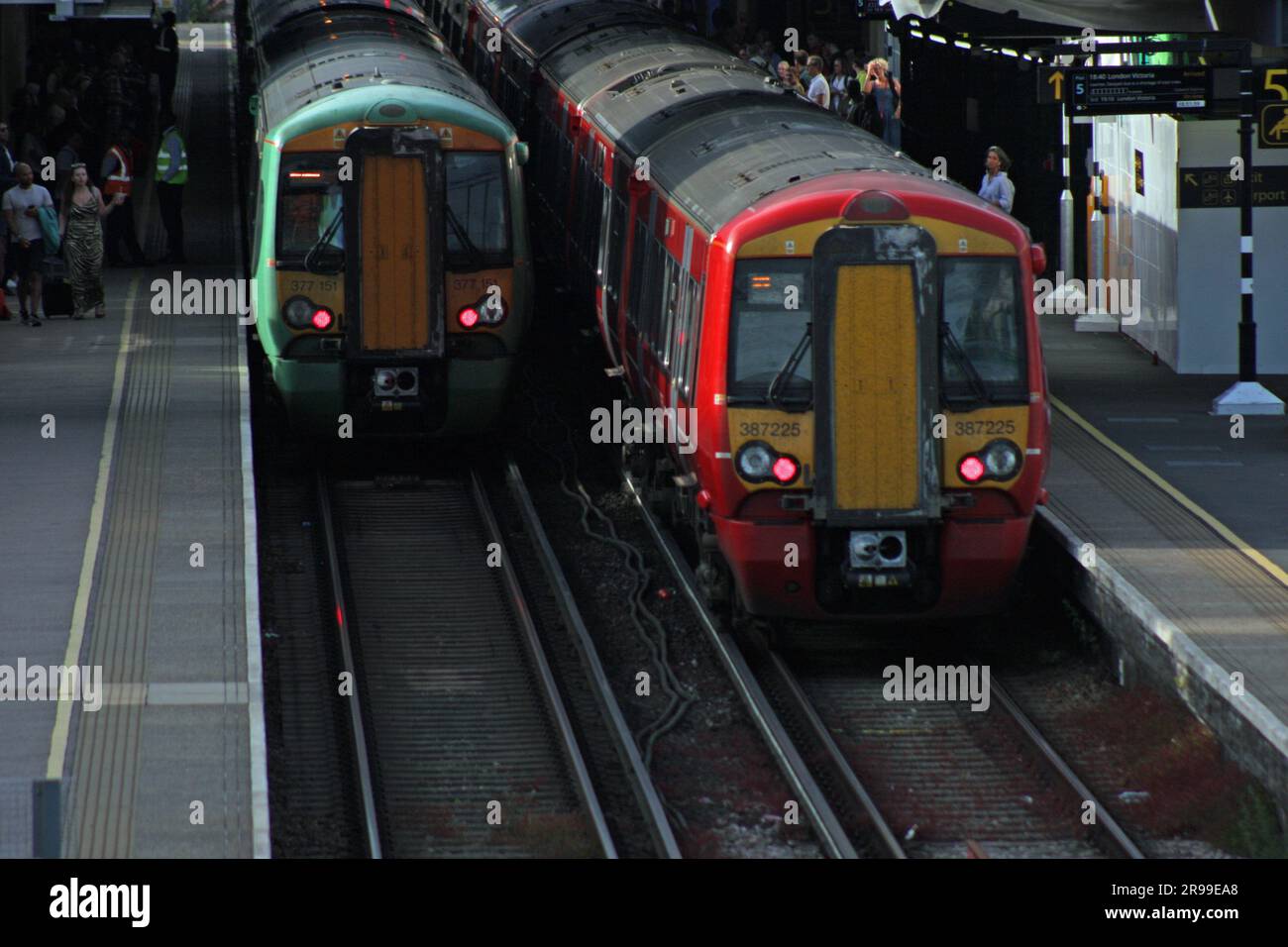 Un treno Gatwick Express in partenza dalla stazione ferroviaria dell'aeroporto di Gatwick accanto a un treno Southern Rail Foto Stock