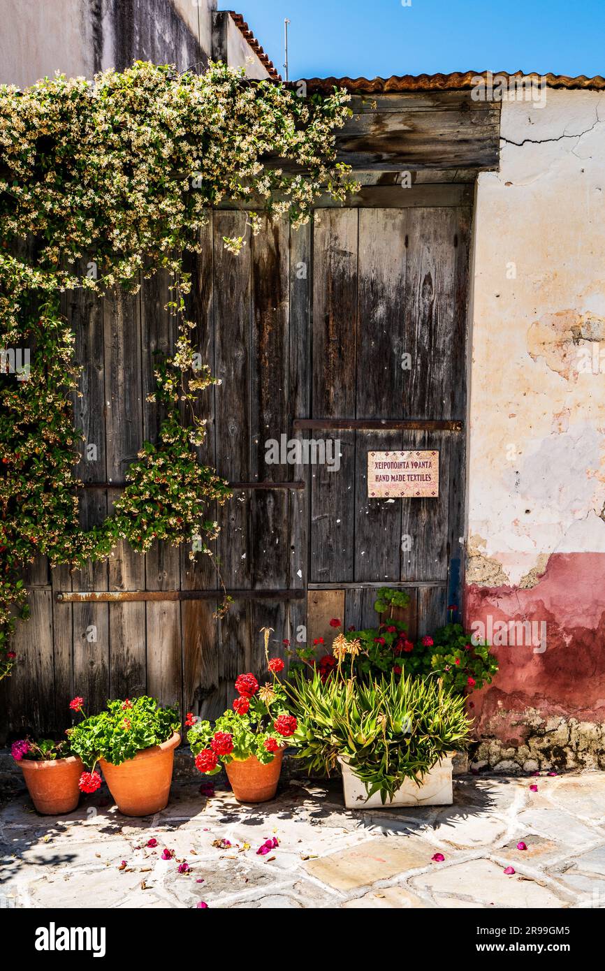 Tradizionale casa cicladica con facciata imbiancata e vasi di fiori colorati ad Halki, Naxos, Grecia Foto Stock