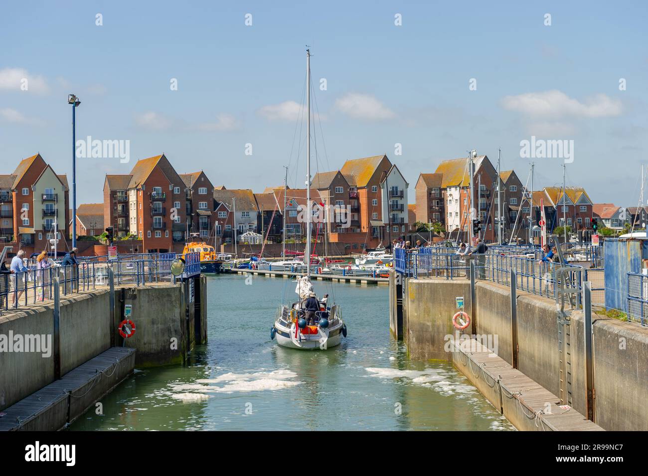 Una barca olandese che passa attraverso la chiusa ed entra nel porticciolo di Soveriegn Harbour, Eastbourne, East Sussex, Inghilterra Foto Stock