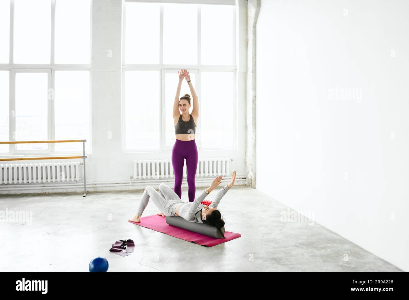 Allenamenti femminili con allenatore di yoga. Lezioni private con personal trainer e istruttore di fitness. Allenamento, esercizi a casa sul tappetino fitness. Sport equi Foto Stock