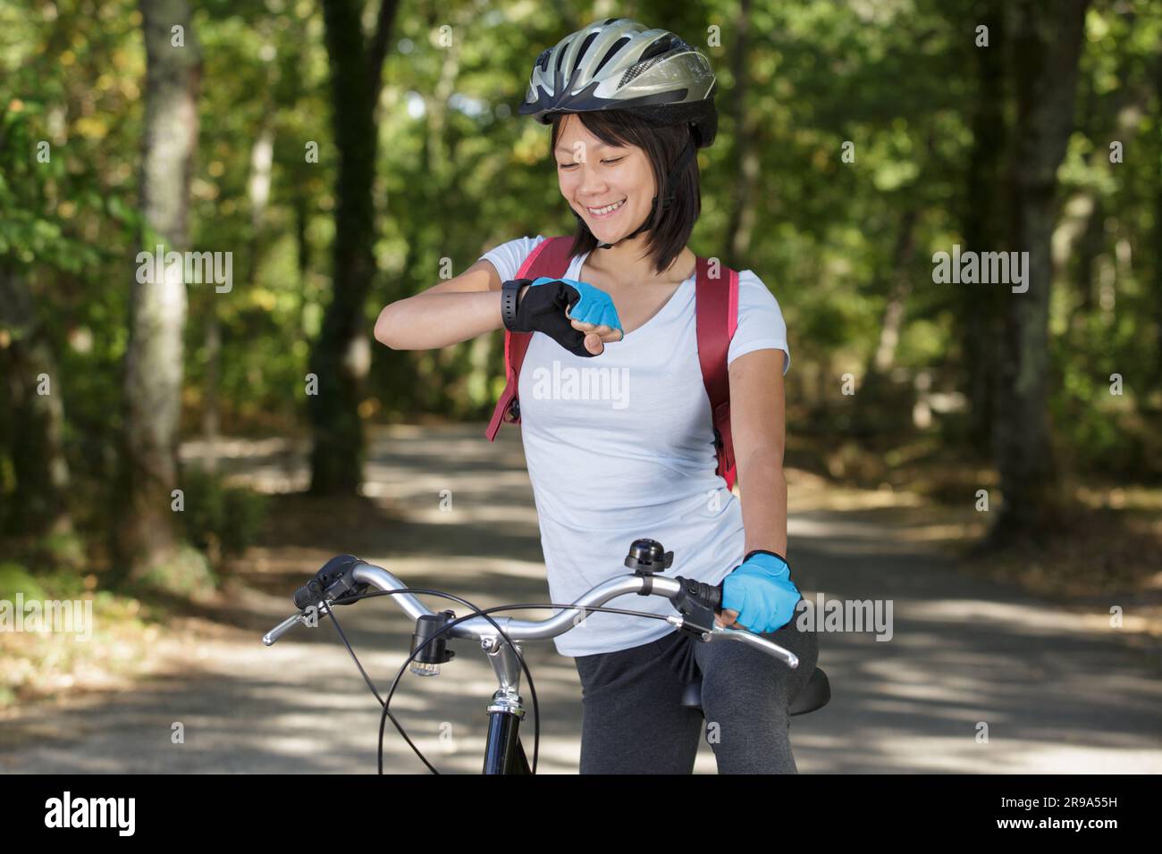 donna in forma che controlla il suo orologio Foto Stock