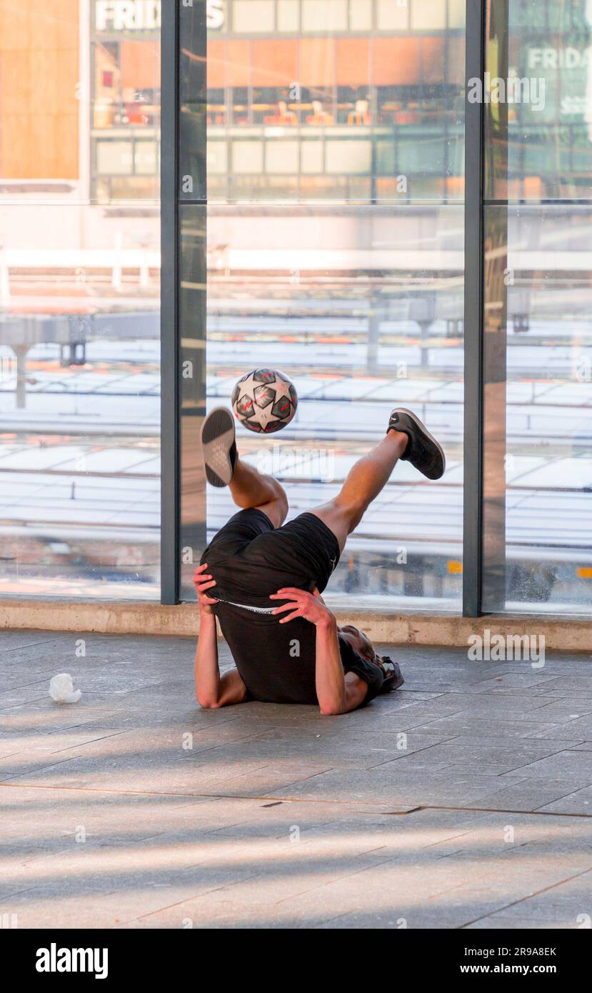 Utrecht, NL - 9 ottobre 2021: Giovane artista olandese che mostra le sue abilità acrobatiche con un calcio alla stazione centrale di Utrecht, nei Paesi Bassi Foto Stock