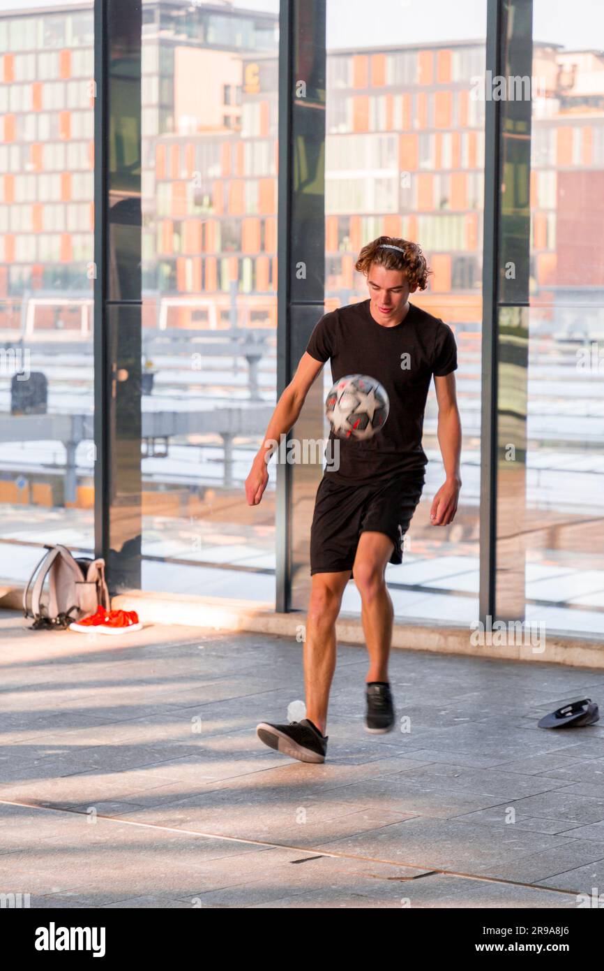 Utrecht, NL - 9 ottobre 2021: Giovane artista olandese che mostra le sue abilità acrobatiche con un calcio alla stazione centrale di Utrecht, nei Paesi Bassi Foto Stock