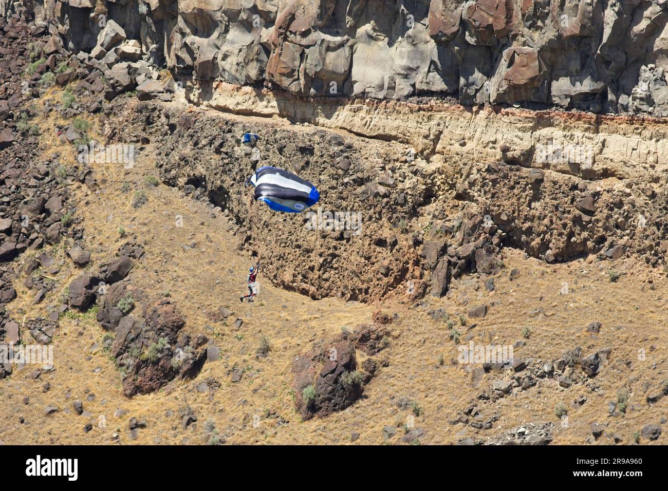 Un salto base paracaduta lungo il canyon in una giornata di sole a Twin Falls, Idaho. Foto Stock