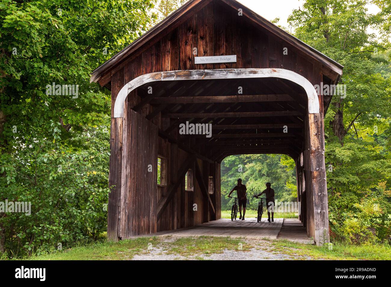 Due persone con biciclette a McWilliams Covered Bridge, Grafton, Vermont, USA Foto Stock