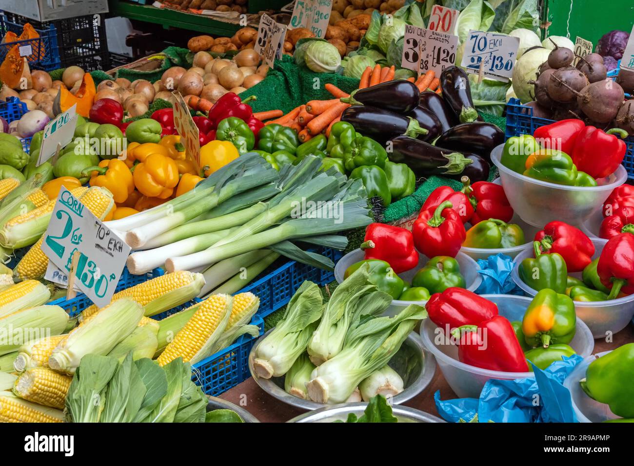 Peperoni, granturco dolce, porri e altri ortaggi in vendita in un mercato a Brixton, Londra Foto Stock