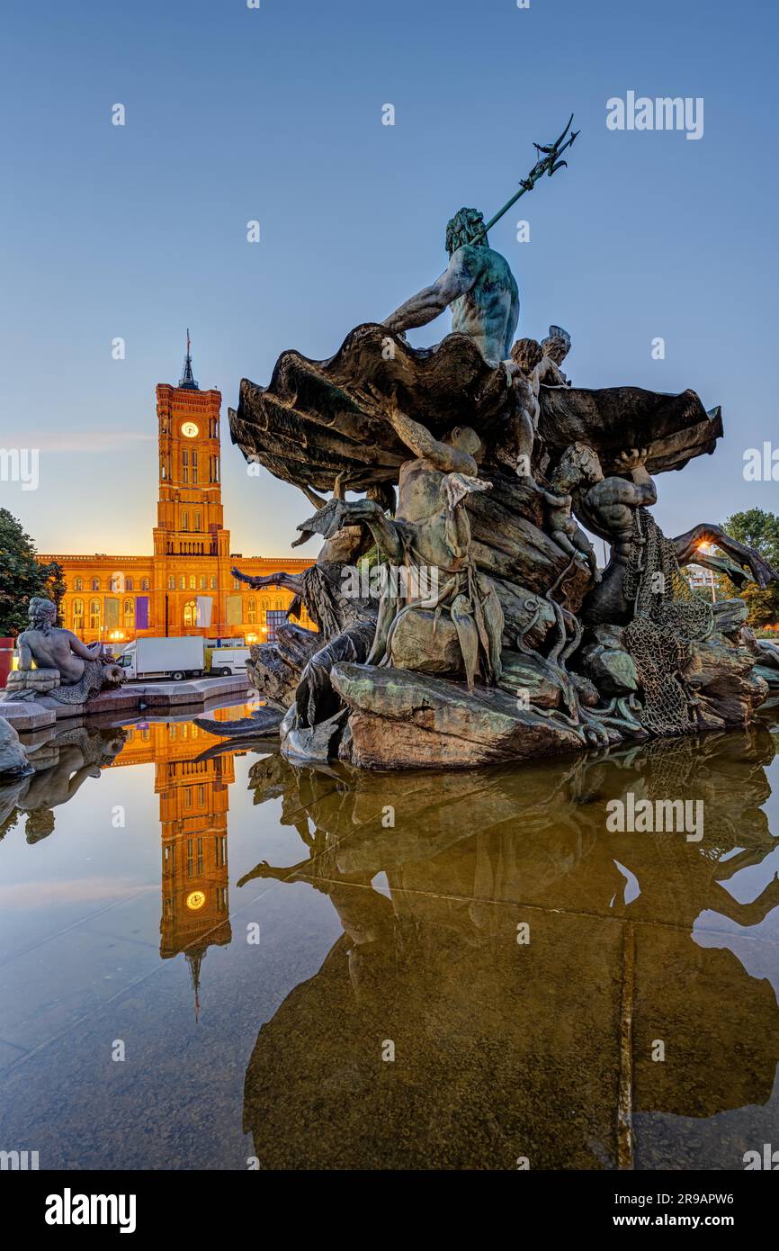 La Fontana di Nettuno ad Alexanderplatz a Berlino al tramonto con il Municipio sullo sfondo Foto Stock