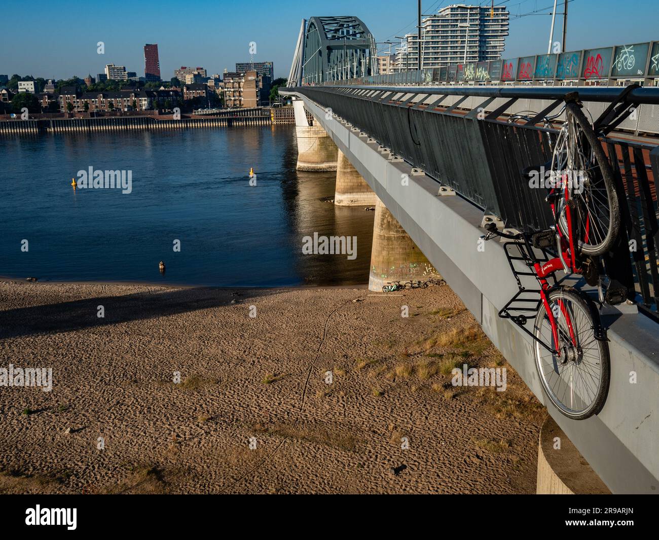 Nijmegen, Paesi Bassi. 25 giugno 2023. Una bici vista appesa a un ponte. Questo fine settimana la gente nei Paesi Bassi potrebbe godere delle temperature calde. Le temperature sono state in grado di raggiungere i 34 gradi nel sud-est del paese. Credito: SOPA Images Limited/Alamy Live News Foto Stock