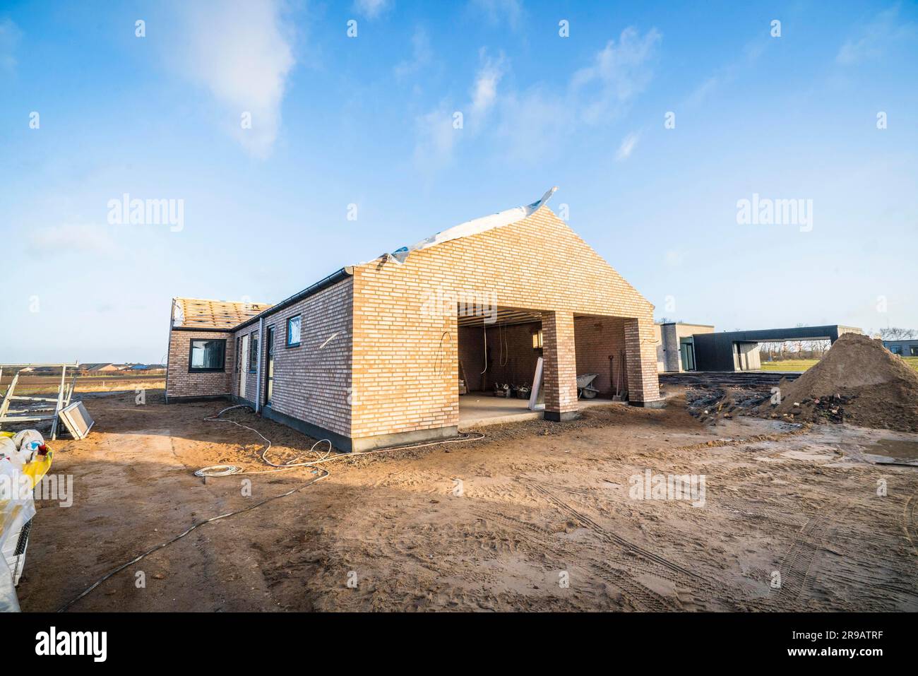 Mattoni casa sito in costruzione in un nuovo quartiere sotto un cielo blu Foto Stock