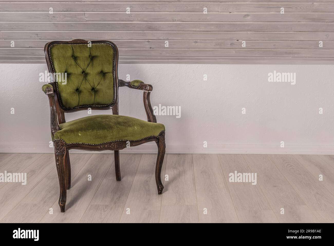 Sedia verde in design vittoriano su pavimento in legno Foto Stock