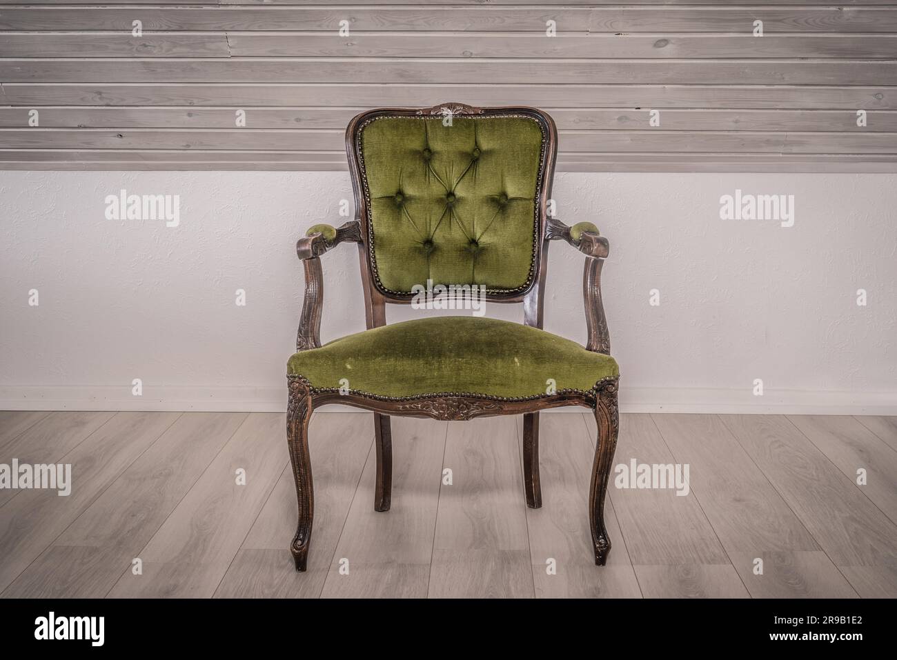 Sedia verde in stile vittoriano su pavimento in legno Foto Stock