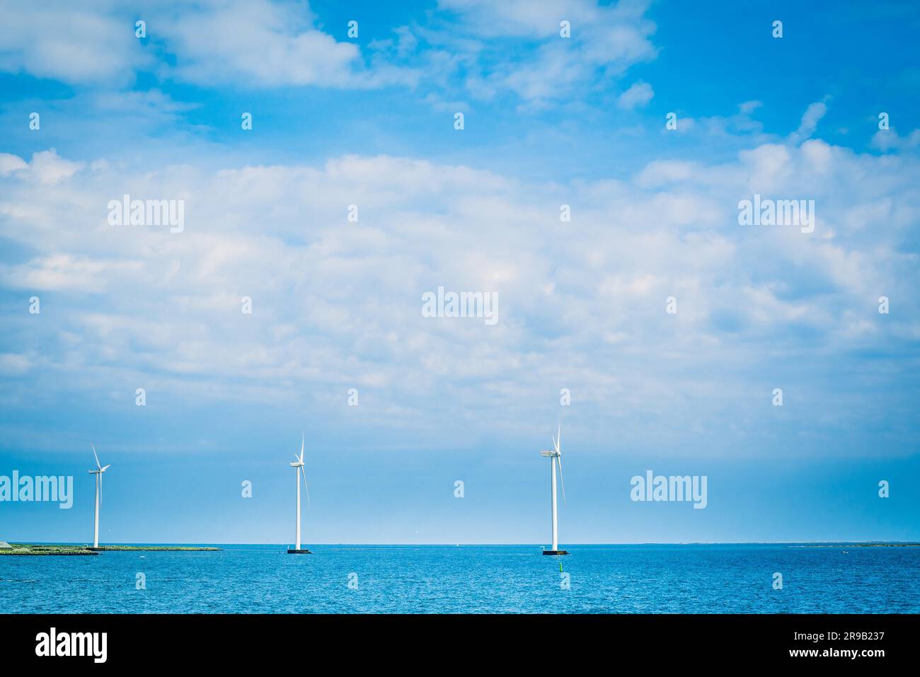 Mulini a vento su una riga nel blu oceano Foto Stock