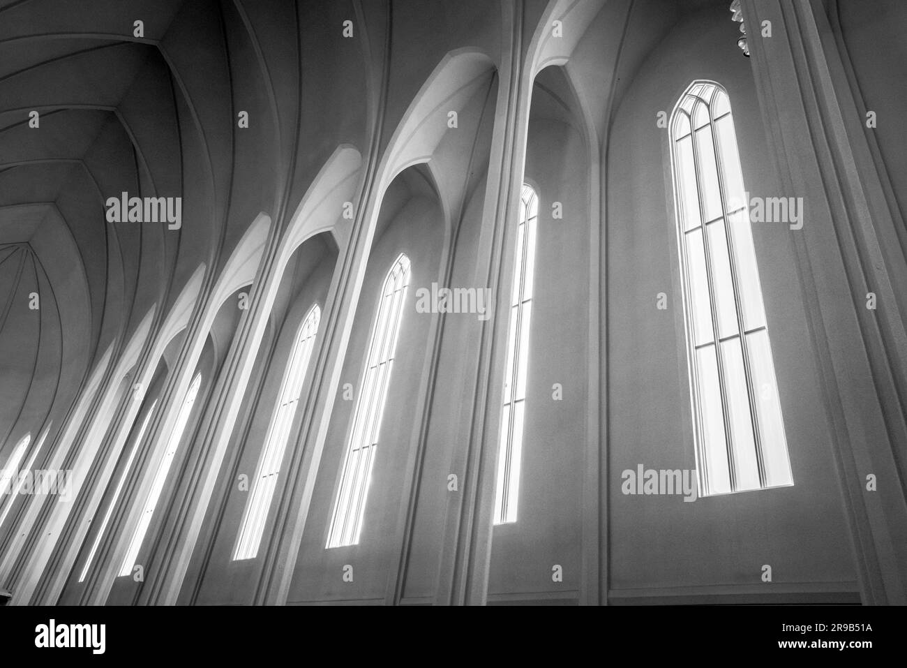 La luce del sole proveniente attraverso finestre alte in una chiesa Foto Stock