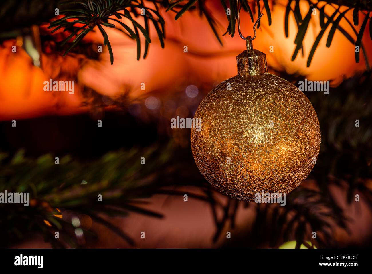 Golden Natale pallina su di un albero con luci scintillanti Foto Stock