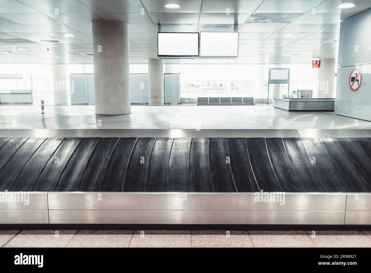 Aeroporto di Lisbona; tiro verticale; attenzione selettiva su una singola borsa nell'area di ritiro bagagli, che si erge contro il pavimento grigio. L'ambiente interno con Foto Stock