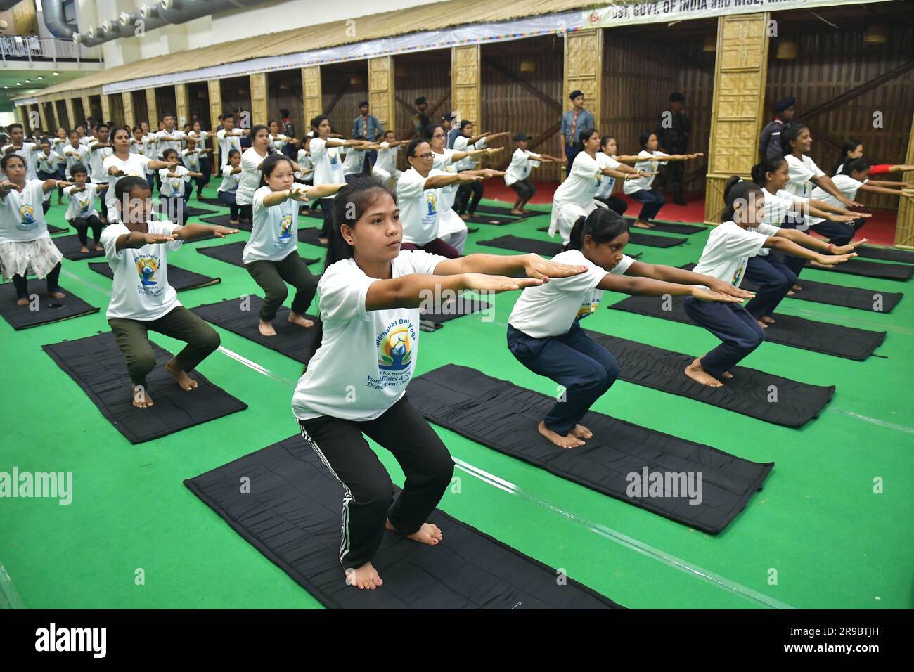 Studenti, personale di sicurezza e funzionari governativi eseguono yoga nella giornata internazionale di Yoga ad Agartala. Tripura, India. Foto Stock