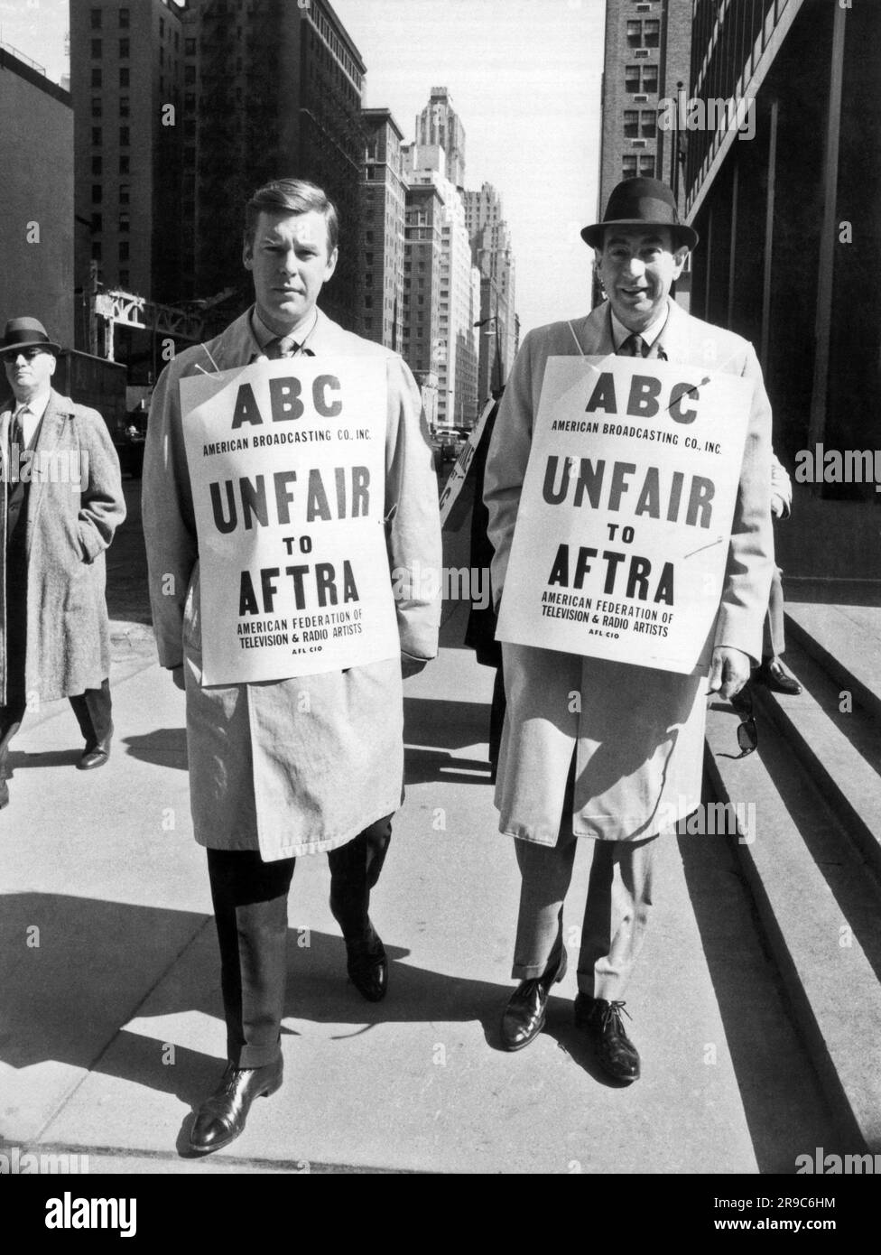 New York, New York: Marzo 1967 Peter Jennings, (L) e il commentatore sportivo Howard Cosell (R) picchetto fuori dagli uffici ABC sulla Avenue of the Americas a sostegno di AFTRA, la American Federation of Television and radio Artists. Foto Stock