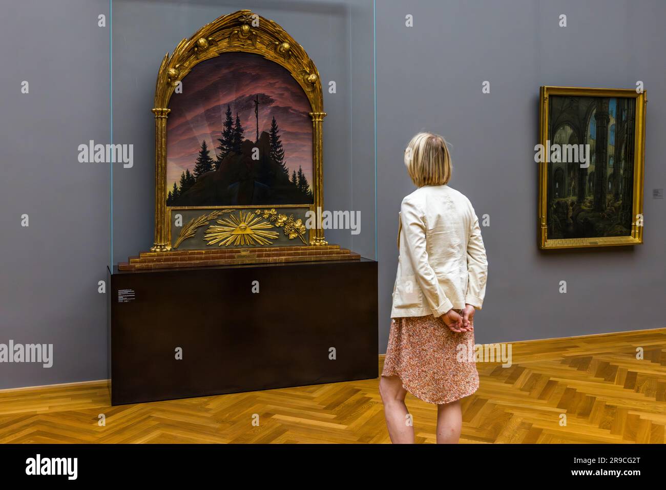 Visitatore ad Albertinum Dresda guardando il dipinto di Caspar David Friedrich, la croce nelle montagne (Tetschen Altar) 1807/1808. Le opere d'arte di Caspar David Friedrich rimangono permanentemente nella galleria dei nuovi maestri dell'Albertinum a Dresda, in Germania Foto Stock