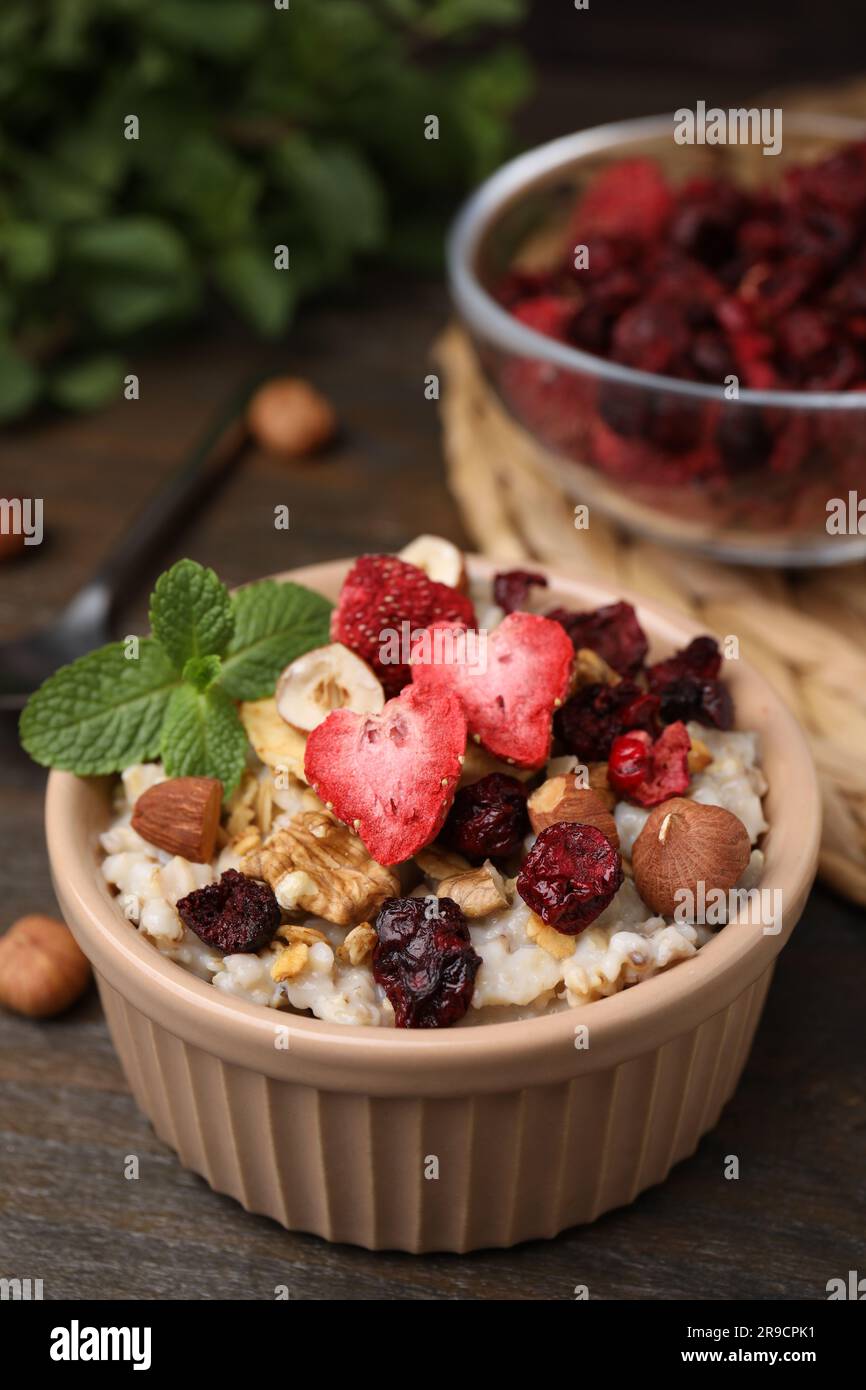 Farina d'avena con frutta liofilizzata, noci e menta su tavolo di legno Foto Stock