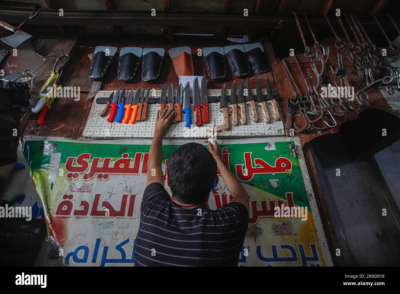 Gaza City, Palestina. 25 giugno 2023. Un impegnato laboratorio di affilatura dei coltelli nella città di Gaza, in vista delle prossime celebrazioni di Eid al-Adha il 25 giugno 2023. EID al-Adha o ''Festa del sacrificio'' è una grande festa nell'Islam che viene celebrata l'ultimo giorno del pellegrinaggio Hajj. È tradizione sacrificare un animale come una pecora o una capra durante Eid al-Adha, per ricordare l'obbedienza del Profeta Ibrahim a Dio. Foto di Habboub Ramez/ABACAPRESS.COM credito: Abaca Press/Alamy Live News Foto Stock