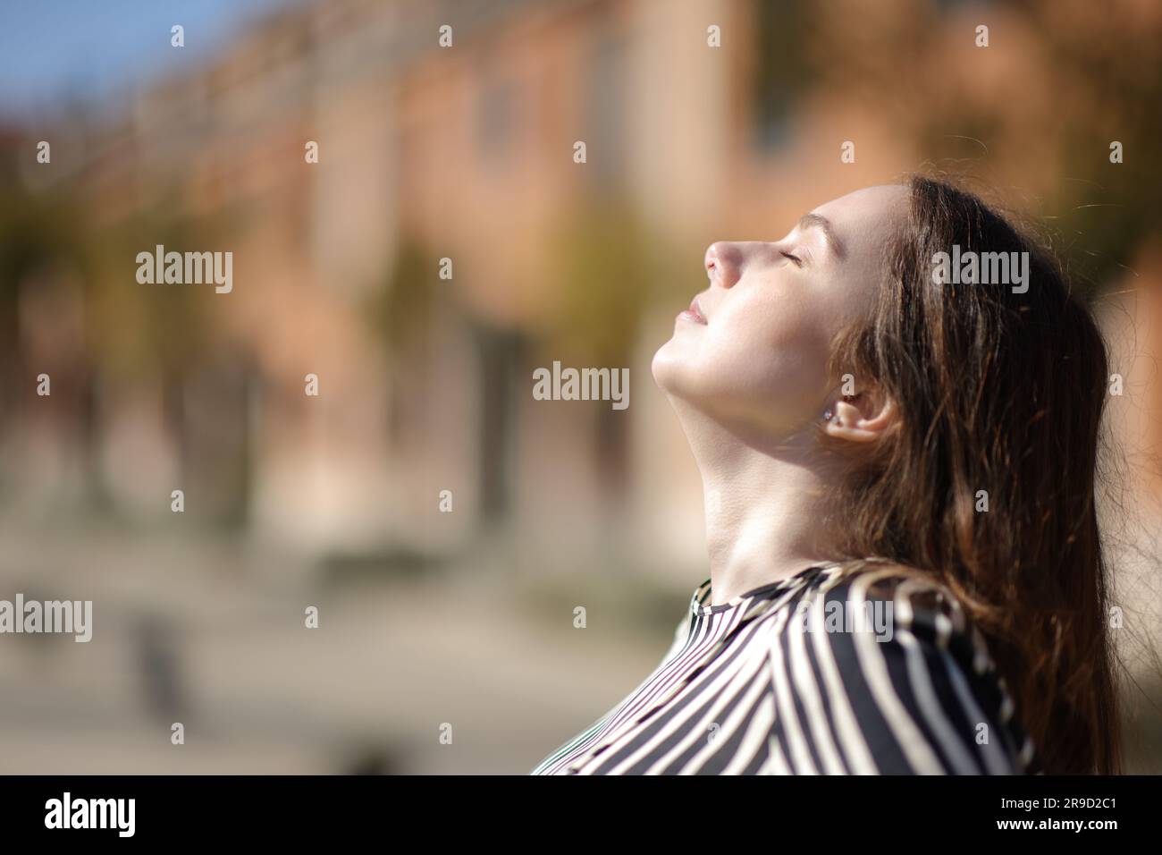 Vista laterale ritratto di una donna elegante che respira aria frangia in una zona residenziale Foto Stock