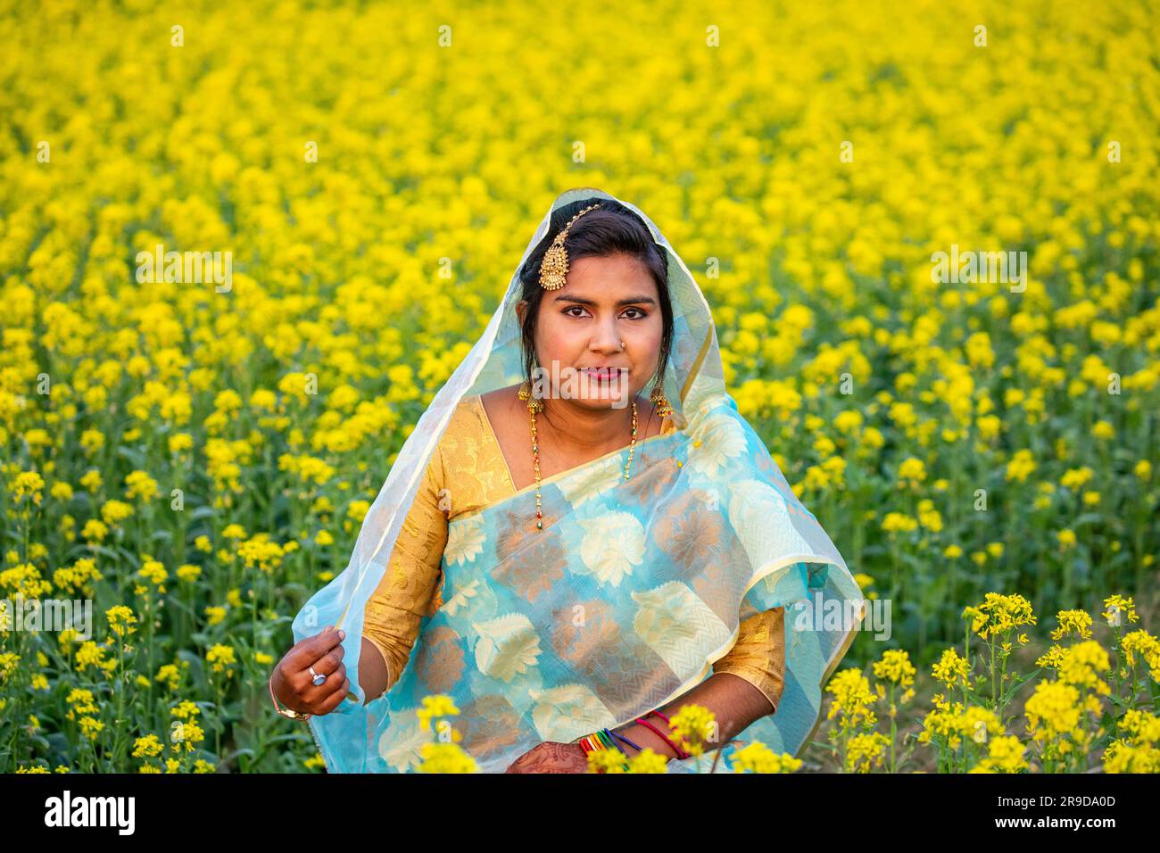 Una donna rurale del Bangladesh appena sposata all'interno di un campo di senape a Singair a Manikganj, Bangladesh. Foto Stock