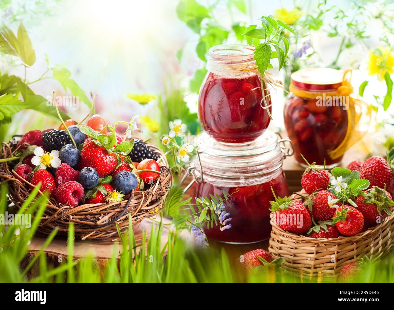 bacche fresche estive in cesti e marmellata fatta in casa in vasetti Foto Stock