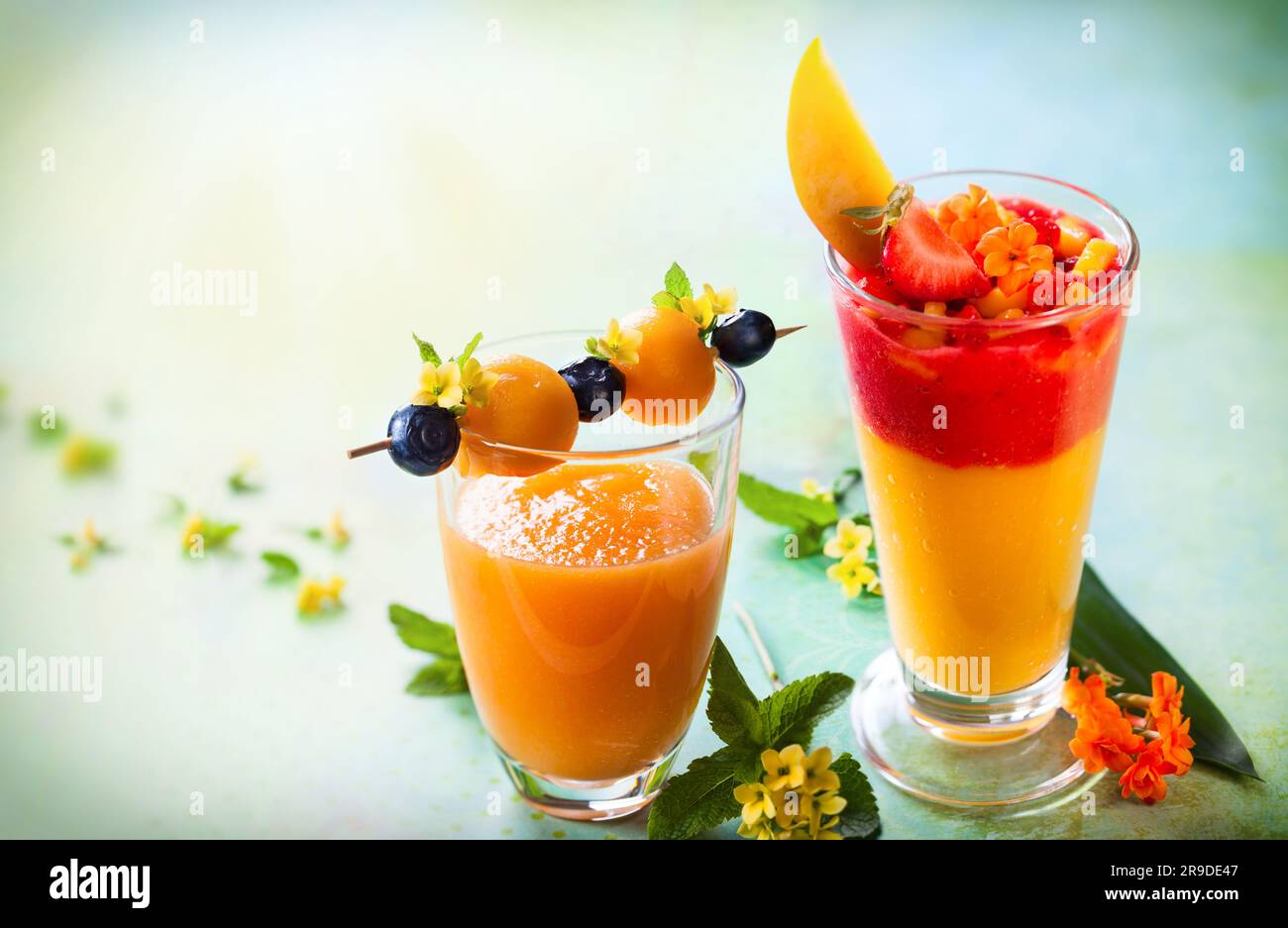 Frullato di melone, mango e fragole con spiedino di frutta Foto Stock