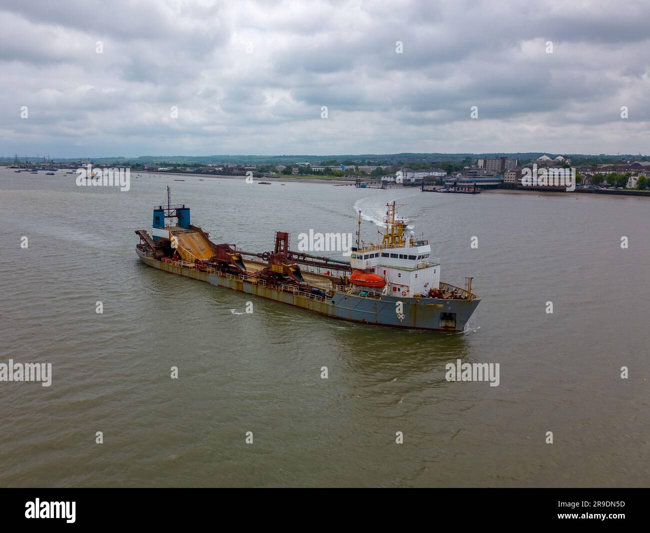 Foto aerea con drone di una grande nave merci che naviga sul fiume Tamigi e sui Tilbury Docks in Inghilterra. Foto Stock