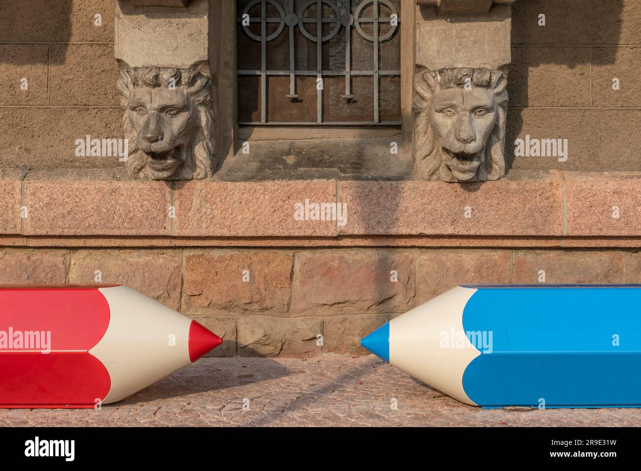 Due divertenti panchine a forma di matita blu e rossa nel centro storico di Porto Ceresio, Italia Foto Stock