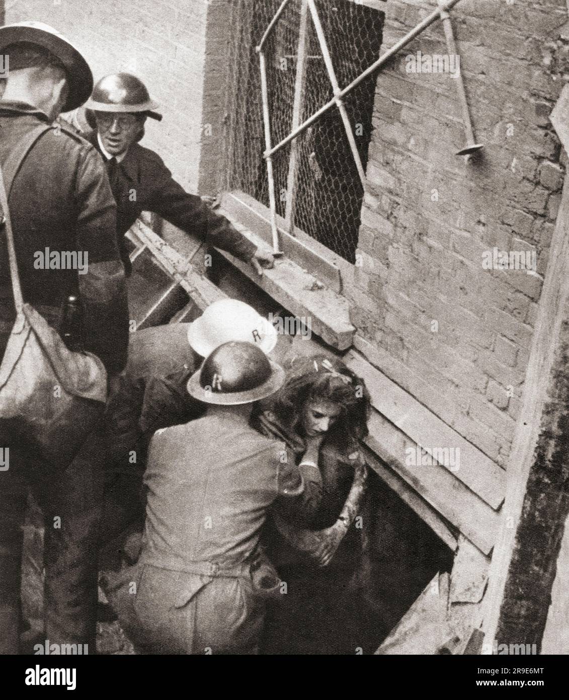 La vittima di un bombardamento diurno nel centro di Londra, ottobre 1940, durante la seconda guerra mondiale, viene sollevata da un seminterrato distrutto. Da Front Line 1940-41, pubblicato nel 1942 Foto Stock