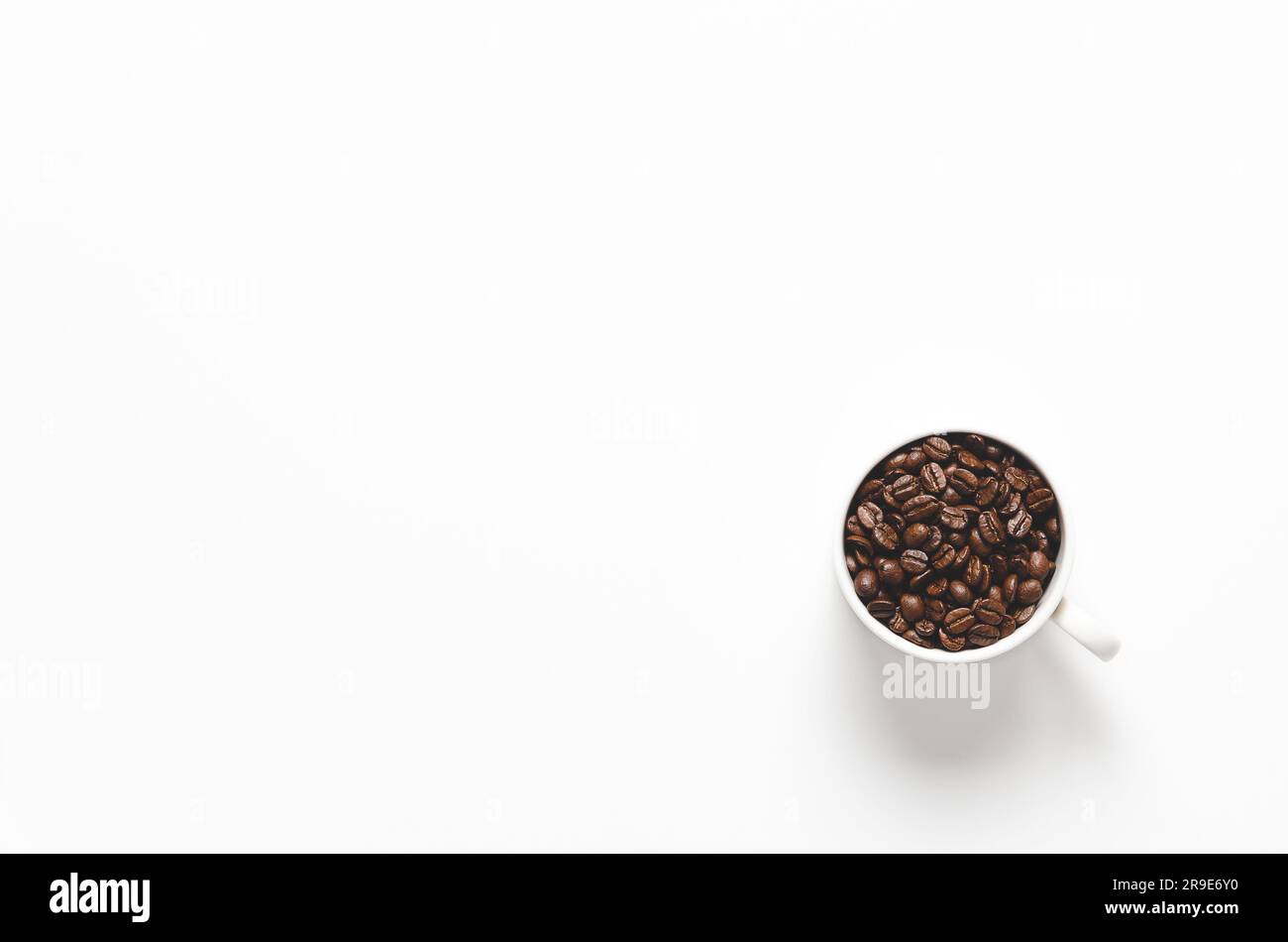 Una tazza di chicchi di caffè su sfondo bianco con spazio per la copia. Foto Stock