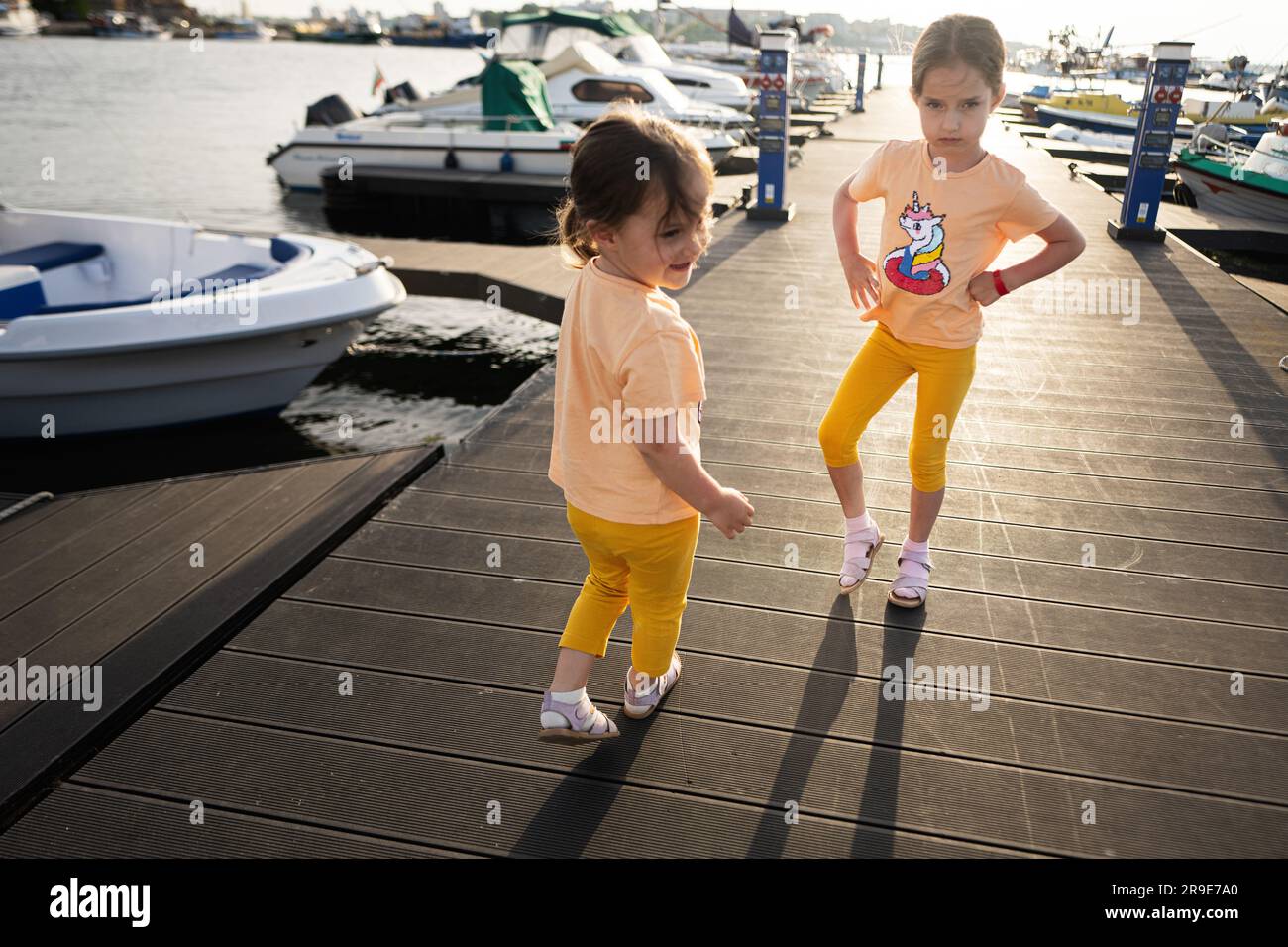 Due sorelle bambine che giocano sul molo nel porto di Nessebar, Bulgaria. Foto Stock