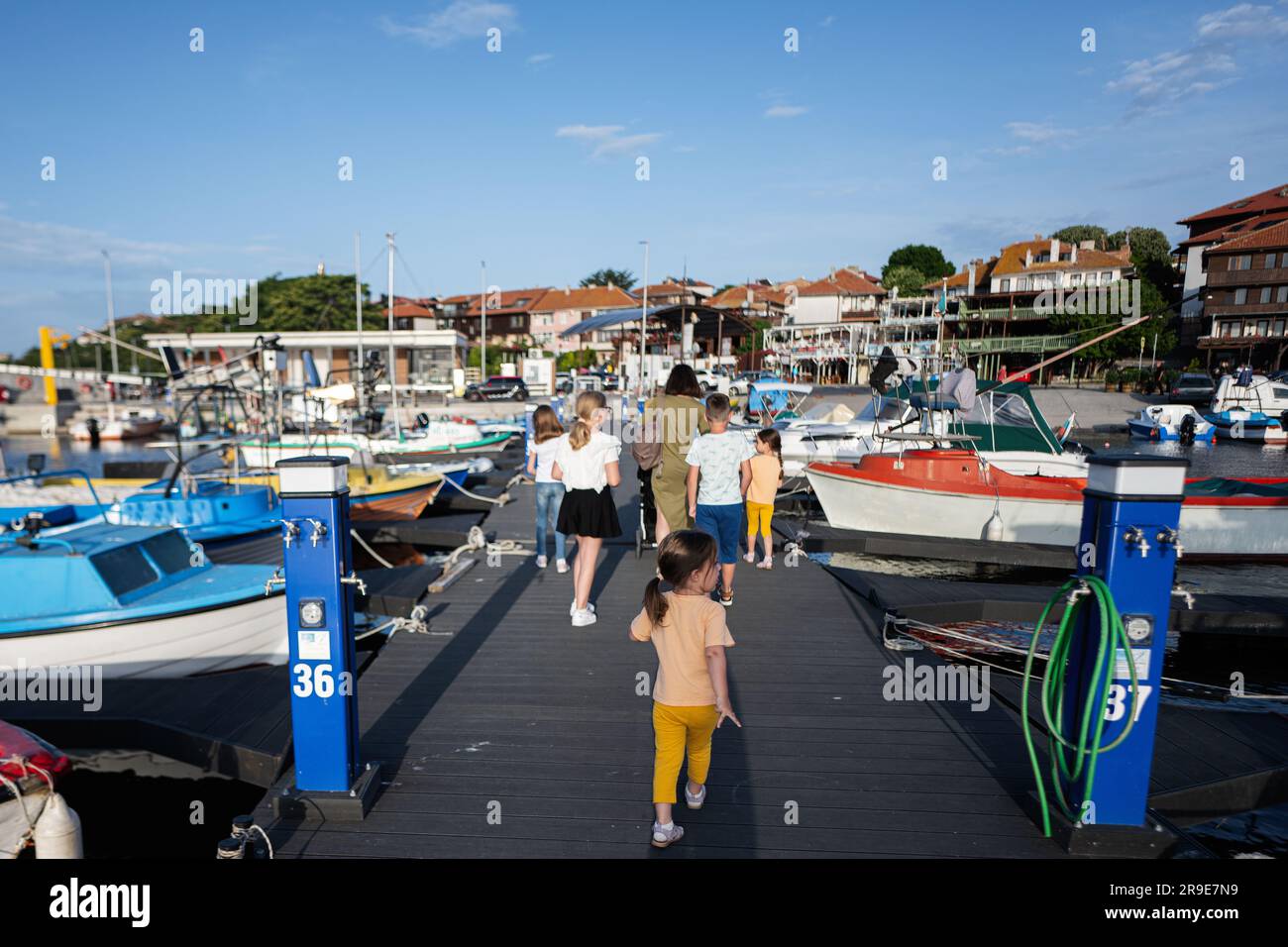 Turisti su un molo nel porto di Nessebar, madre con bambini. Foto Stock