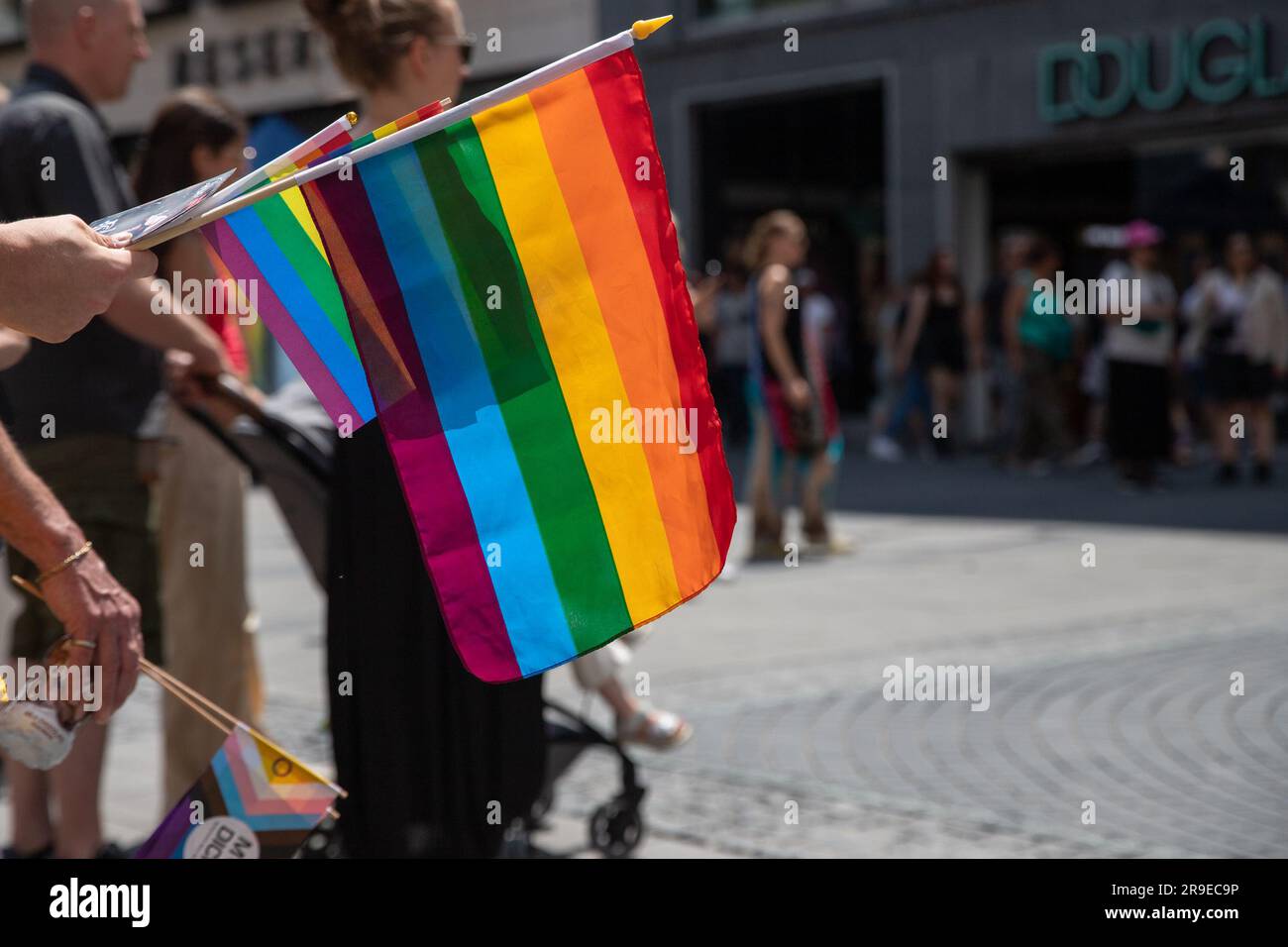 Monaco, Germania, 24 giugno 2023: Primo piano delle bandiere arcobaleno detenute da un uomo durante il Gay Pride a Monaco Foto Stock