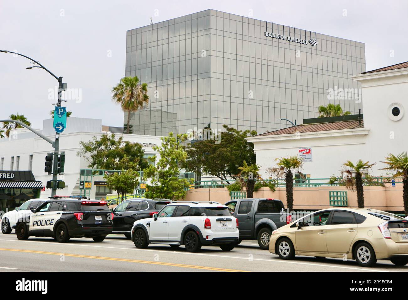 Edificio della Bank of America con traffico di passaggio e un'auto della polizia Beverly Hills Los Angeles California USA Foto Stock