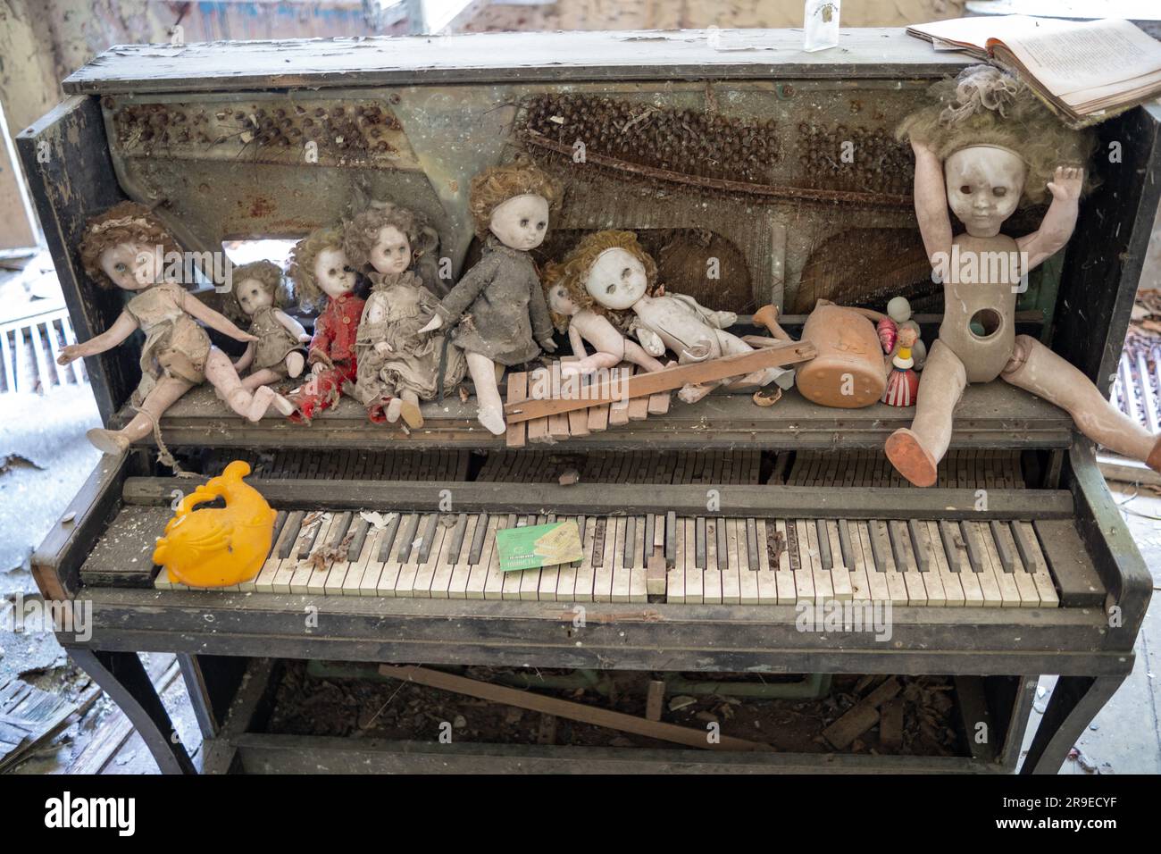 Decorazione interna di case private abbandonate con pianoforte e bambole nella zona di esclusione della Bielorussia Foto Stock