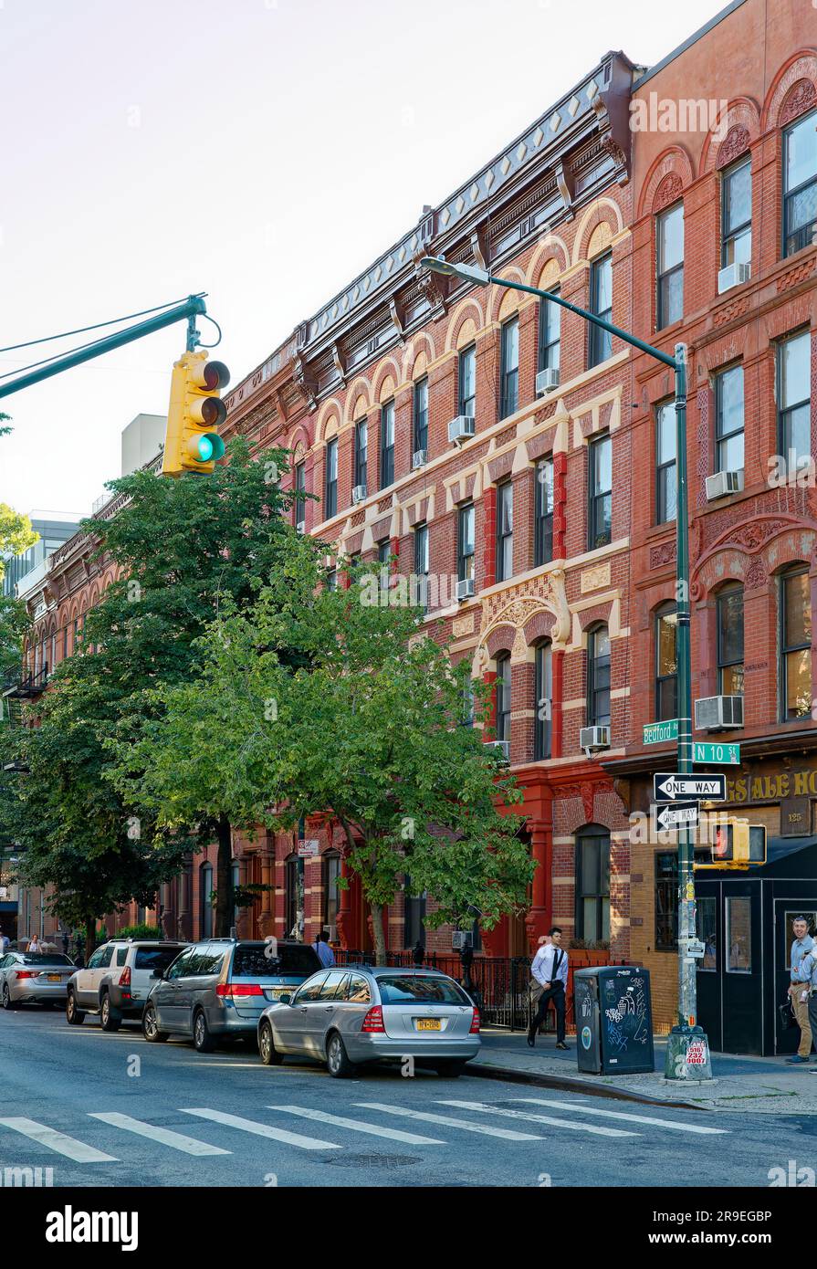 123 Bedford Avenue è un basso edificio di appartamenti nel nord di Williamsburg; la sua muratura è stata dipinta di rosso e dettagli in terracotta dipinti d'oro. Foto Stock