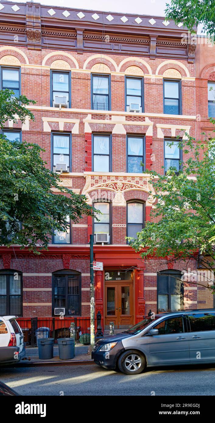 123 Bedford Avenue è un basso edificio di appartamenti nel nord di Williamsburg; la sua muratura è stata dipinta di rosso e dettagli in terracotta dipinti d'oro. Foto Stock