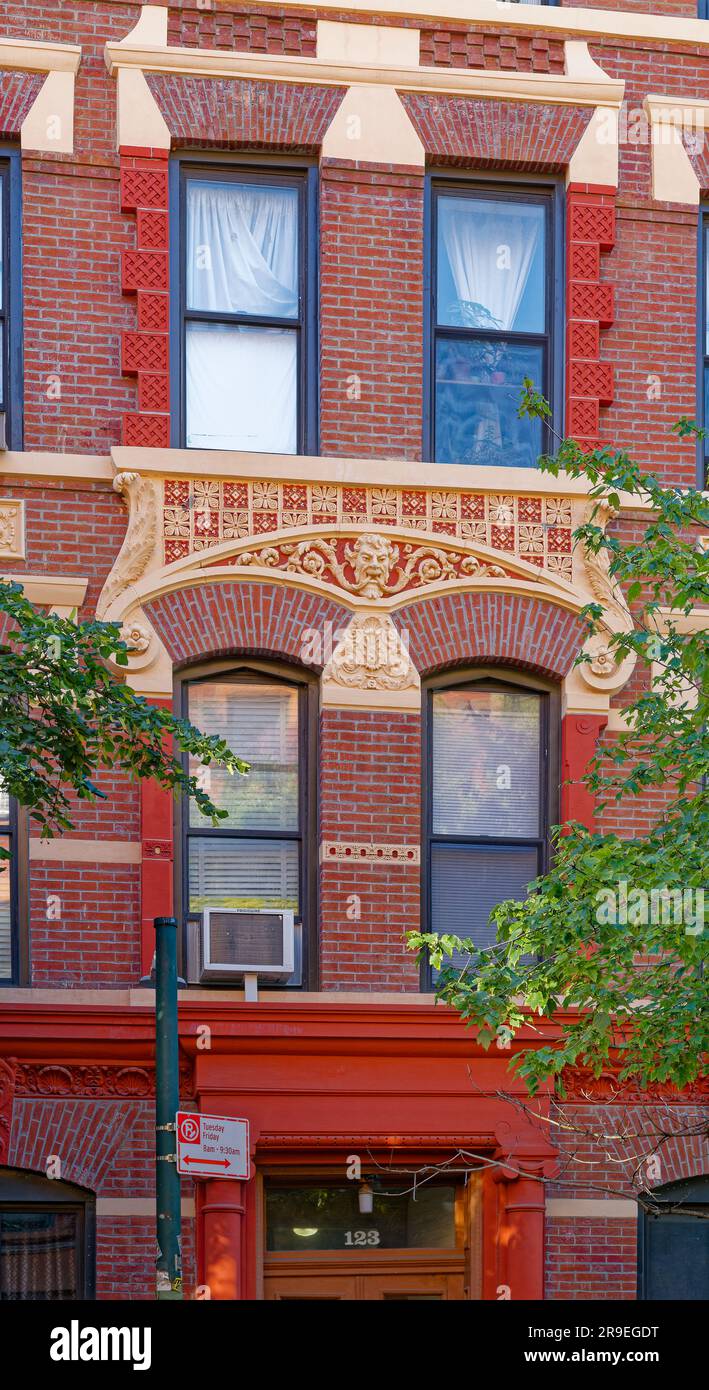 123 Bedford Avenue è un basso edificio di appartamenti nel nord di Williamsburg; la sua muratura è stata dipinta di rosso e dettagli in terracotta dipinti d'oro. Foto Stock