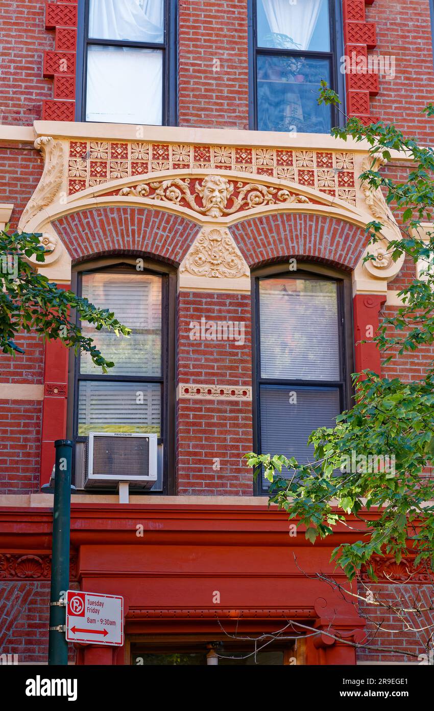 123 Bedford Avenue è un basso edificio di appartamenti nel nord di Williamsburg; la sua muratura è stata dipinta di rosso e dettagli in terracotta dipinti d'oro. Foto Stock