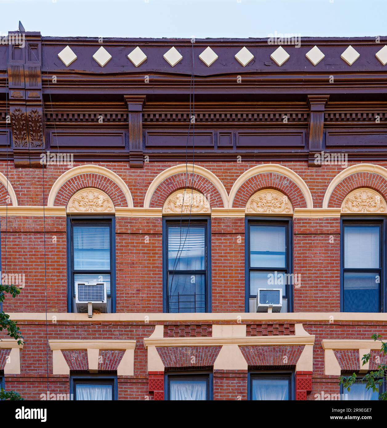123 Bedford Avenue è un basso edificio di appartamenti nel nord di Williamsburg; la sua muratura è stata dipinta di rosso e dettagli in terracotta dipinti d'oro. Foto Stock