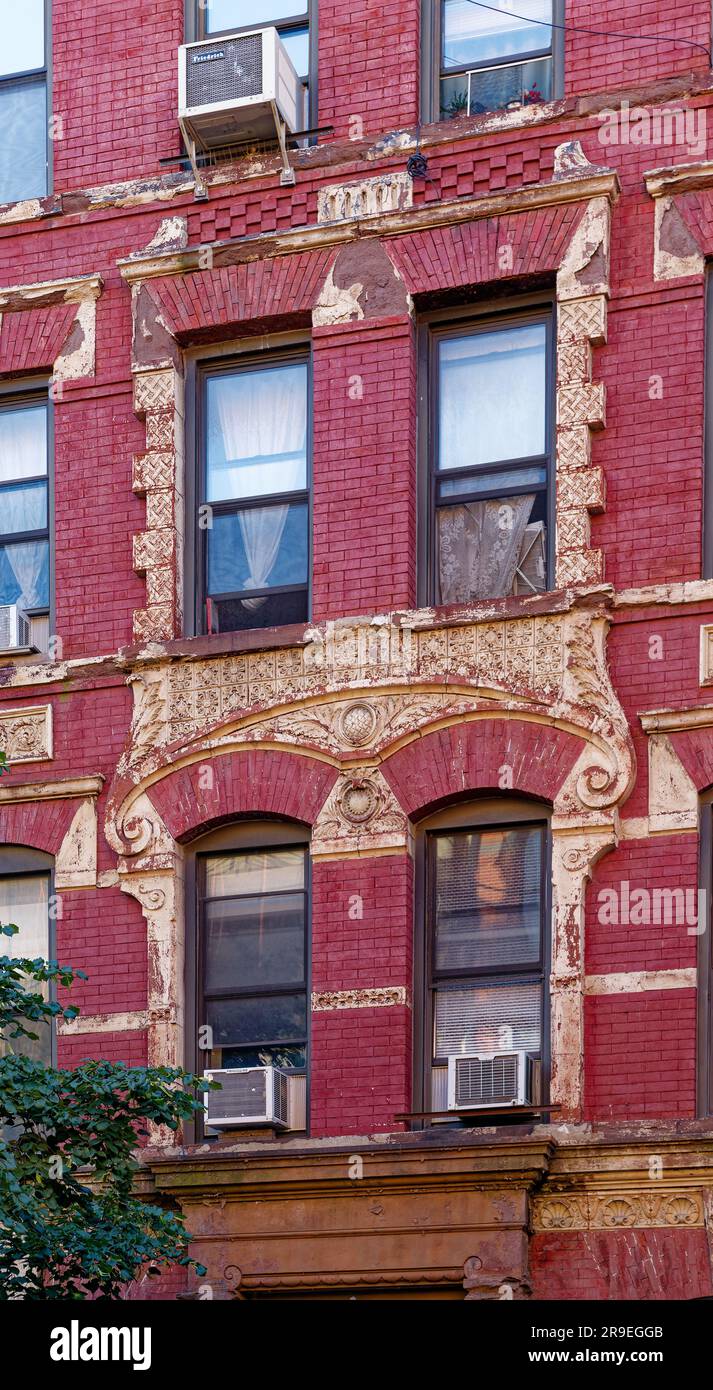 119 Bedford Avenue è un basso edificio di appartamenti nel nord di Williamsburg; la sua muratura è stata dipinta di rosso e dettagli in terracotta dipinti d'oro. Foto Stock