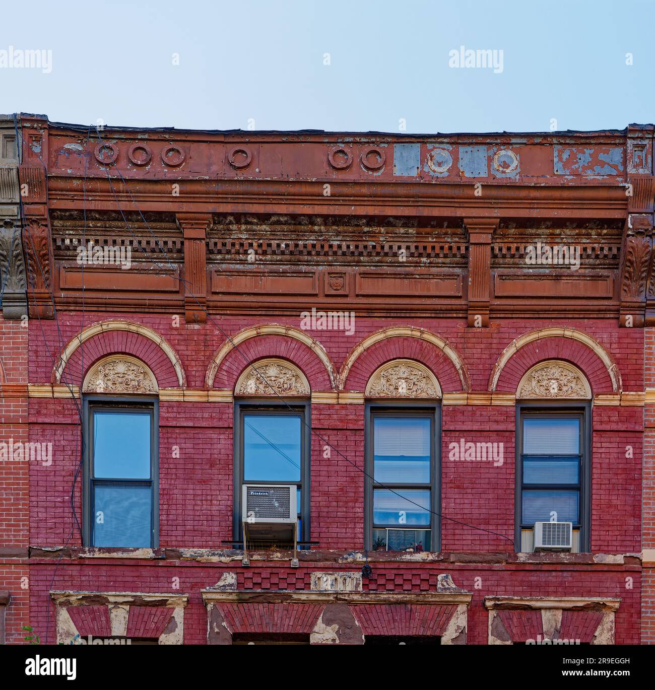 119 Bedford Avenue è un basso edificio di appartamenti nel nord di Williamsburg; la sua muratura è stata dipinta di rosso e dettagli in terracotta dipinti d'oro. Foto Stock