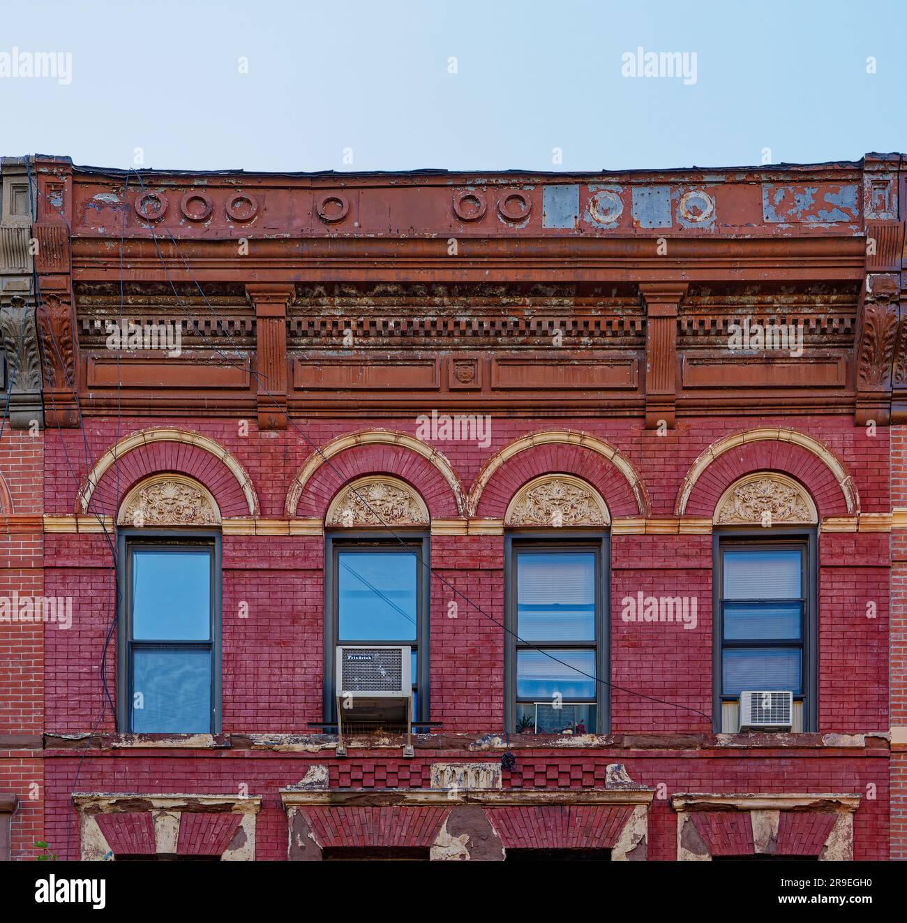 119 Bedford Avenue è un basso edificio di appartamenti nel nord di Williamsburg; la sua muratura è stata dipinta di rosso e dettagli in terracotta dipinti d'oro. Foto Stock