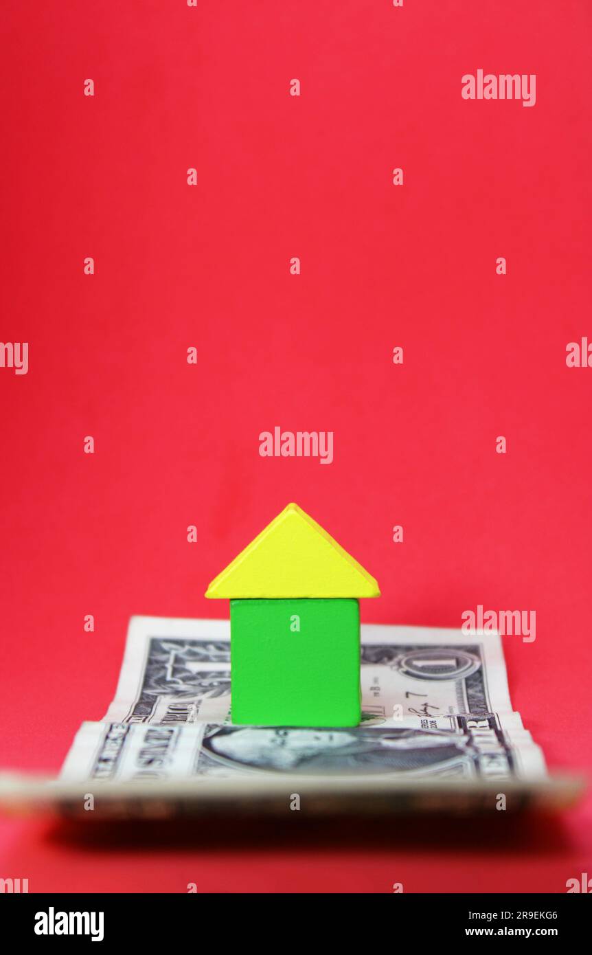 Casa formata con figure geometriche su banconota da dollaro Foto Stock