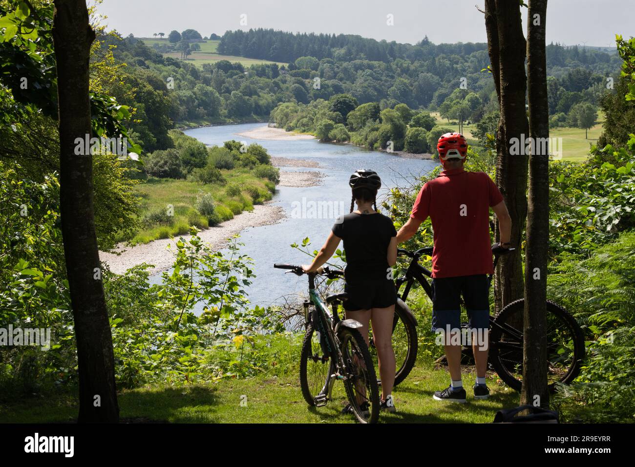 I ciclisti ammirano la vista del fiume Dee sulla Deeside Way (National Cycle Route 195) vicino a Peterculter, Aberdeen, Scozia, Regno Unito Foto Stock