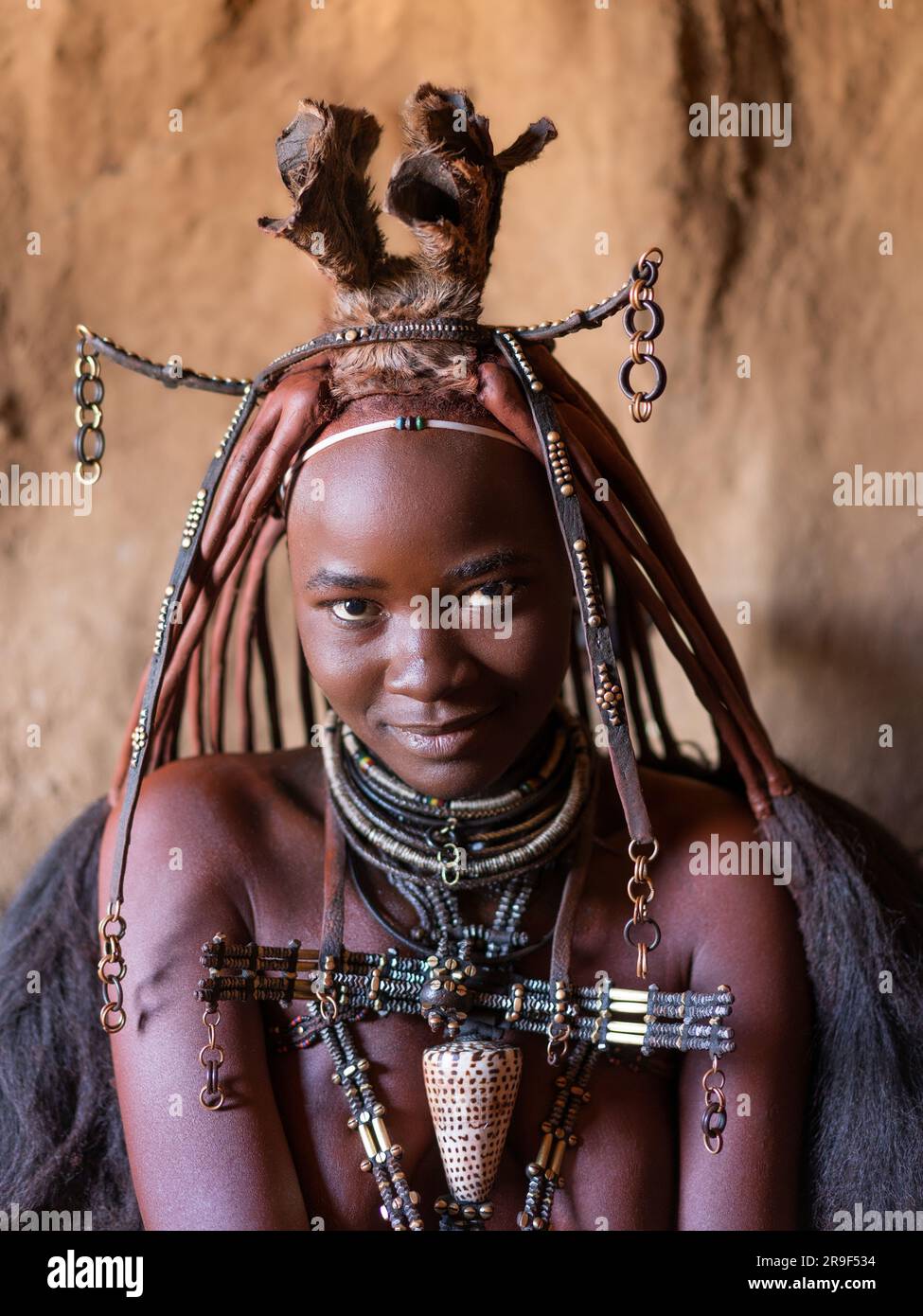 Giovane donna Himba che indossa gioielli tradizionali nel suo villaggio in Namibia, in Africa. Foto Stock