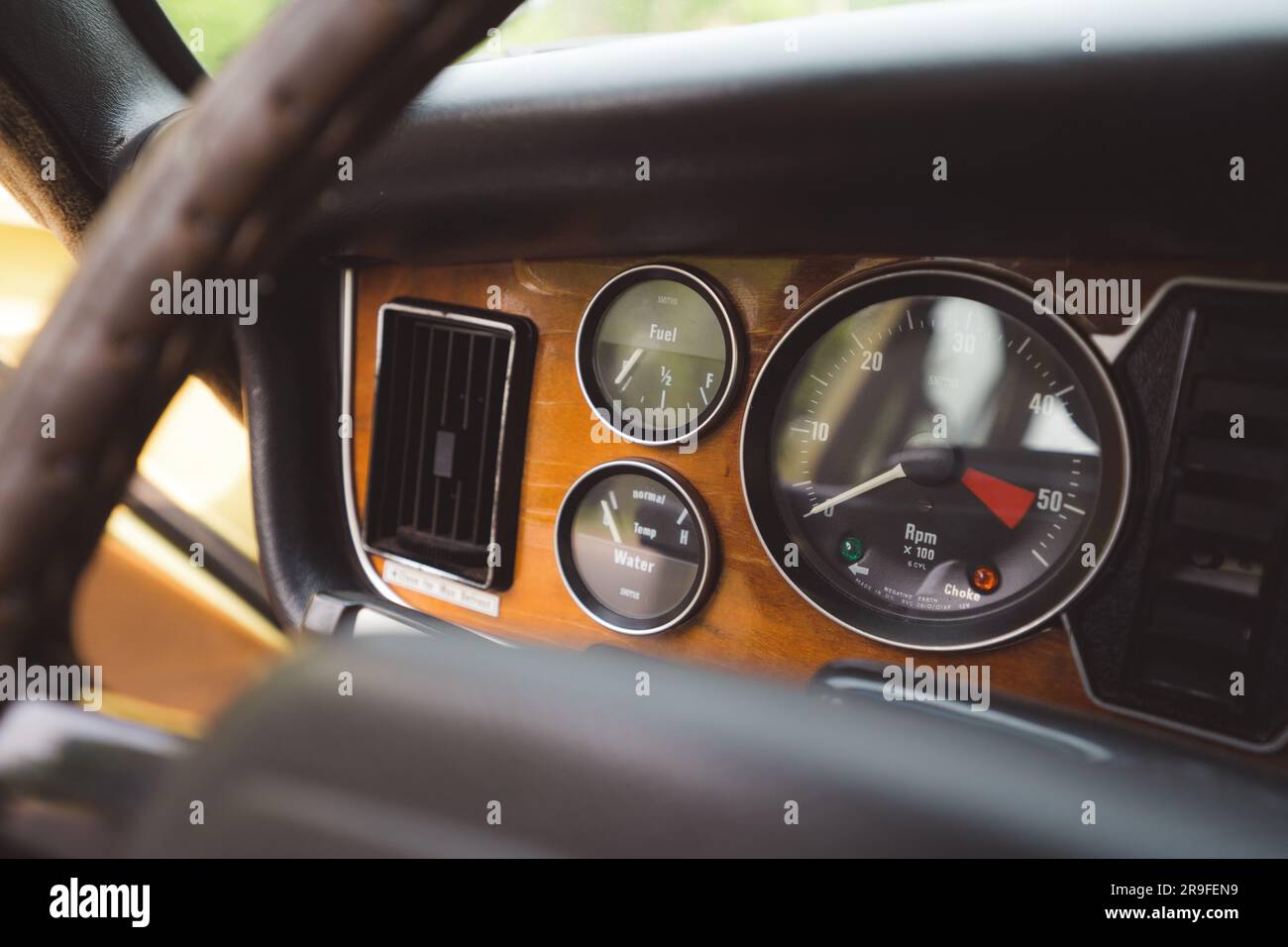 Vista interna di un'auto d'epoca, con cruscotto con una varietà di quadranti e indicatori Foto Stock