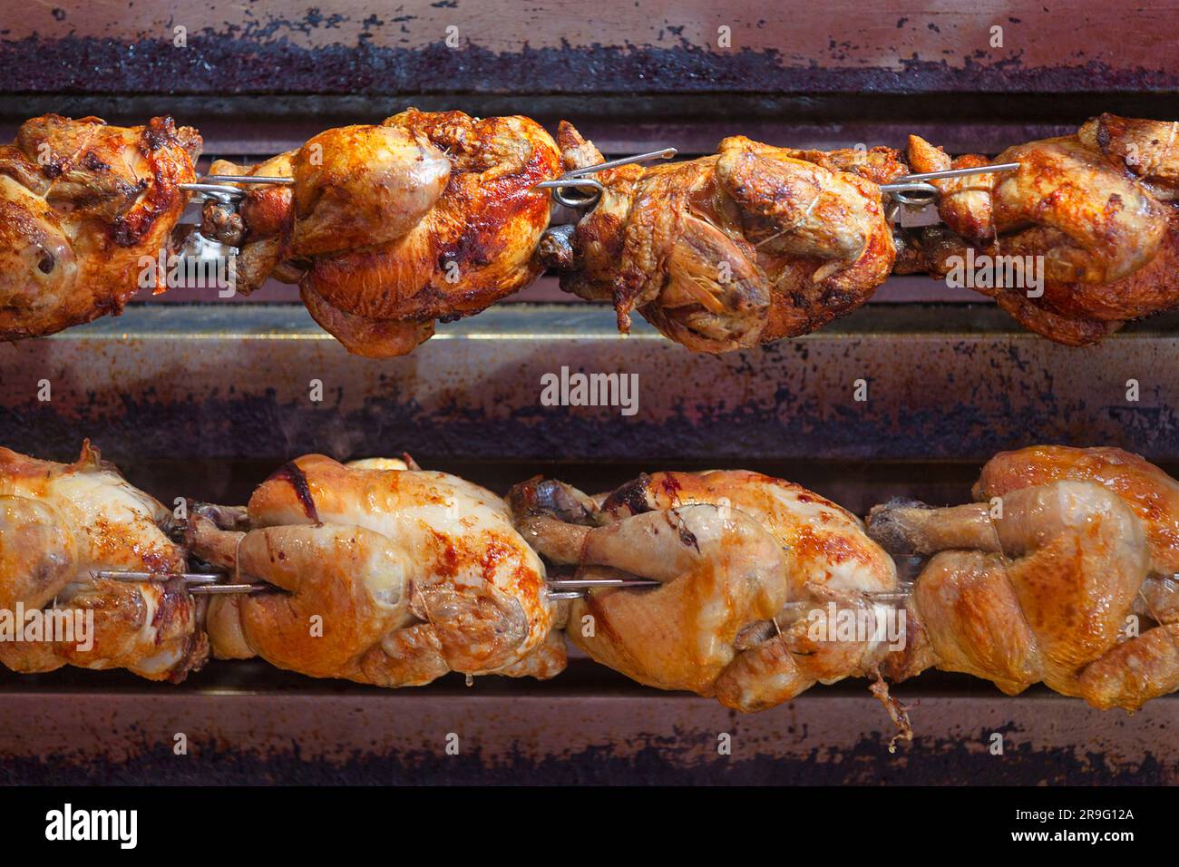 Un pollo arrosto è un piatto di pollo che viene cotto su un girarrosto utilizzando il calore diretto in cui il pollo viene posto accanto alla fonte di calore. Foto Stock